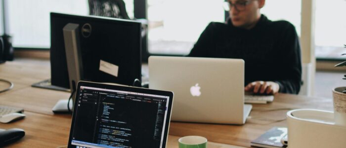 pexels-photo-2102416-2102416 A web developer working on code in a modern office setting with multiple devices.