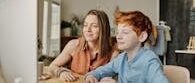 A mother and her son engaging in online learning at home, fostering education and connection.